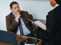 focused diverse coworkers discussing business project in office