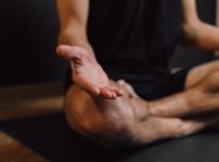 man practicing meditation on sports mat